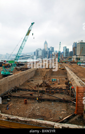 Bonifica di terreni a Hong Kong il Victoria Harbour con lo skyline in background Foto Stock