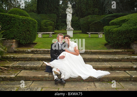 Ritratto orizzontale di una sposa e lo sposo con un po' di tranquillità insieme in un giardino ornamentale il giorno delle nozze. Foto Stock