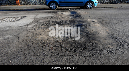 Regno Unito buche in una strada in Seaford East Sussex causati dal freddo inverno Foto Stock