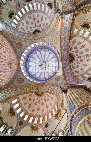 Blue Mosque Dome Interior Istanbul Turchia // ISTANBUL, Turchia — Moschea del Sultano Ahmed (turco: Sultanahmet Camii), popolarmente conosciuta come la Moschea Blu, è una moschea musulmana (sunnita) nel centro del quartiere della città vecchia di Istanbul, Sultanahmet. Fu commissionato dal sultano Ahmed i e completato nel 1616. L'interno della moschea è rinomato per le sue splendide piastrelle blu Iznik e l'intricata calligrafia, che adornano le cupole e le pareti, creando un'esperienza visiva mozzafiato. Foto Stock