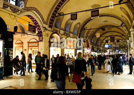 Grand Bazaar Street Scene Istanbul Turchia // ISTANBUL, Turchia - Una strada trafficata sulla via principale dello storico Grand Bazaar di Istanbul. Le strade del bazar sono tutte coperte, con i soffitti spesso decorati. Il Grand Bazaar, uno dei mercati coperti più grandi e antichi del mondo, è un vivace centro commerciale e culturale di Istanbul. Caratterizzato da un labirinto di oltre 4.000 negozi, offre una vivace gamma di prodotti, da spezie e gioielli a tessuti e ceramiche. L'architettura storica e l'atmosfera vivace del Grand Bazaar attirano milioni di visitatori ogni anno. Foto Stock