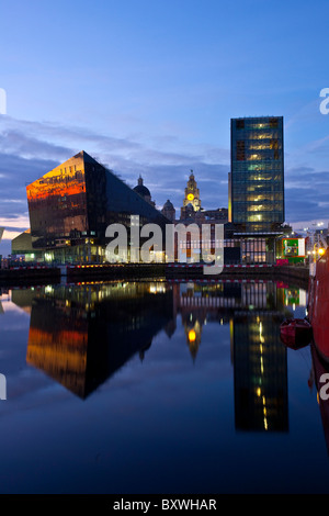 Tramonto sul Mersey dockland; pareti di vetro edificio. Inscatolando dock riflessi del tramonto dell'isola di Mann lo sviluppo, Liverpool, Merseyside, Regno Unito Foto Stock