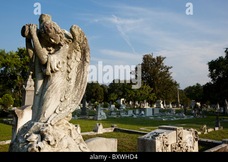 Stati Uniti d'America, Georgia, savana, Statua di angelo cristiano e la croce tra le statue del cimitero al Cimitero Cattolico sulla serata estiva Foto Stock