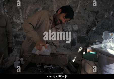 Uomo pakistano dal Nord aree di blocco di rasatura del ghiacciaio dalla Karakoram Mountain Range per fare il ghiaccio bevande fredde in estate Foto Stock