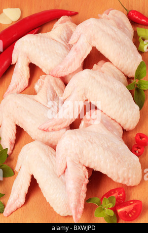 Materie di ali di pollo su un tagliere Foto Stock