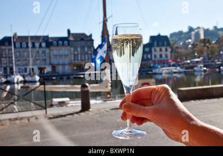 Sollevamento di un bicchiere di champagne in Honfleur Brittany Foto Stock