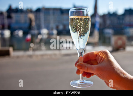 Sollevamento di un bicchiere di champagne in Honfleur Brittany cheers Foto Stock