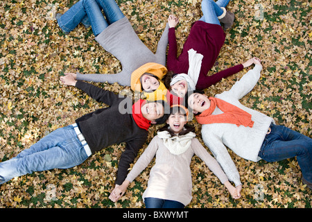 Amici giacente in una forma a stella tenendo le mani Foto Stock