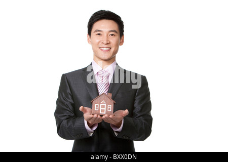 Imprenditore tenendo un piccolo modello in legno home Foto Stock