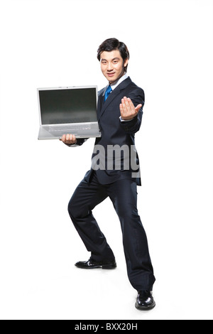 Imprenditore in atteggiamento di combattimento holding laptop Foto Stock