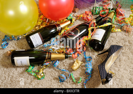 Parte di palloncini con bottiglie di champagne e una donna di tacco alto scarpa Foto Stock