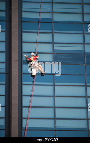 Alto edificio di detergente per vetri attaccato ad una corda Foto Stock