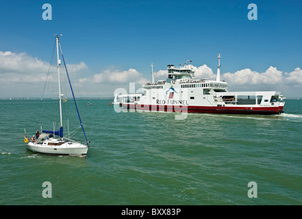 Una barca a vela passa Red Funnel Aquila Rossa nel Solent off Cowes nell'Isola di Wight in Inghilterra Foto Stock