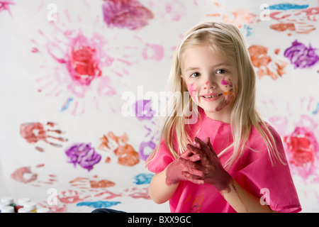 Carino bambina dito pittura isolati su sfondo bianco Foto Stock