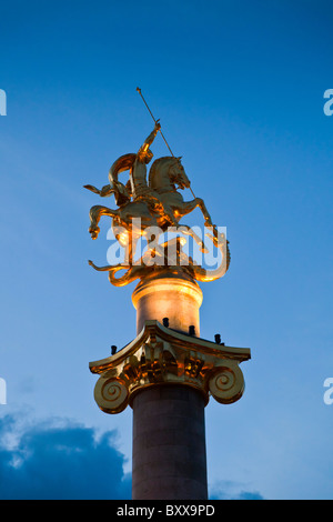 Statua di San Giorgio che uccide il drago sul monumento della libertà e la vittoria in Piazza della Libertà, Tbilisi Georgia al crepuscolo. JMH4077 Foto Stock