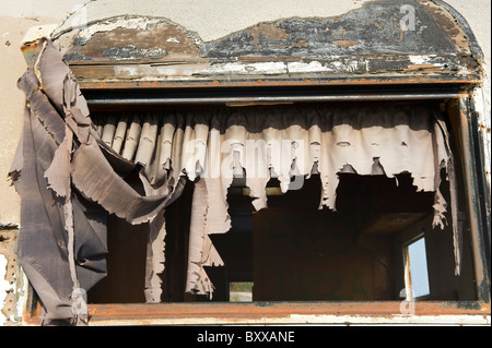 Le tende nella finestra di abbandono di rimorchio o caravan, Salton Sea Beach, nel sud della California, Stati Uniti d'America. Foto Stock