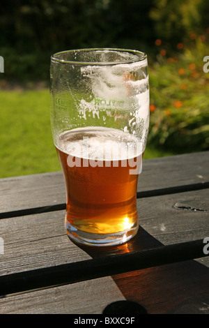 Una pinta bicchiere di real ale birra, mezzo pieno o mezzo vuoto! Foto Stock