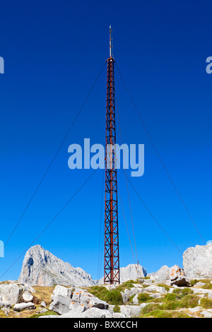 Montante di telecomunicazioni sulla cima di una montagna con cielo blu dietro Foto Stock