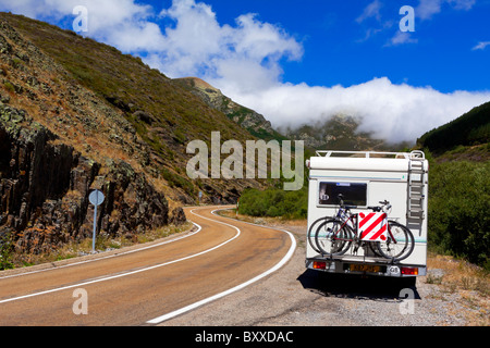 Camper con bici attaccata alla cremagliera del ciclo parcheggiato in una layby su una tortuosa strada di montagna in Picos de Europa Spagna settentrionale Foto Stock