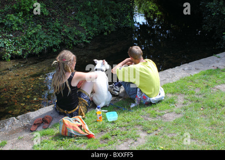 Coppia giovane nel profondo pensiero sulla banca del fiume Stour in Canterbury centro citta'. Eventualmente i senzatetto. Foto Stock