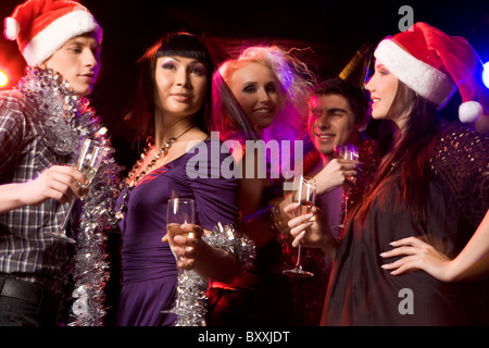 Happy amici con champagne in ballo nel night club durante il party Foto Stock