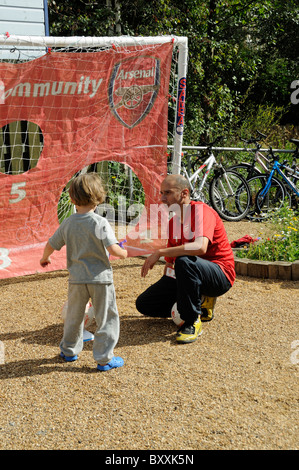 Arsenal nella Comunità, l'uomo con un giovane ragazzo in una sanzione di kick off Gillespie Park, Highbury Londra Inghilterra REGNO UNITO Foto Stock