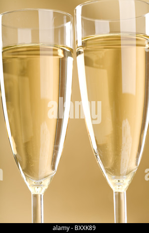 Close-up di due scanalature di champagne su sfondo dorato Foto Stock