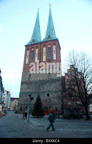 Il twin spired chiesa di San Nicola o Nikolaikirche in Nikolaikircheplatz al tramonto a Berlino, Germania. Foto Stock