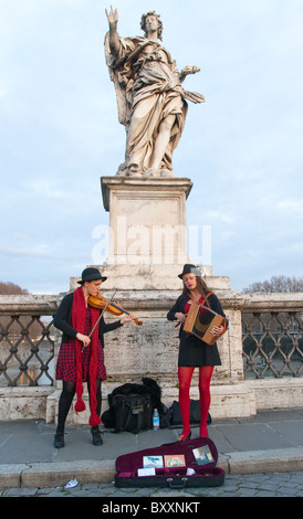 Due donne buskers musicisti di strada a suonare strumenti su San Angelo ponte di Roma Italia Foto Stock