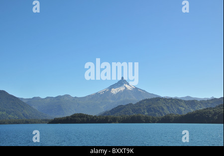 Cielo blu vista della Sharp a punta di cono di ghiaccio di Volcan Puntiagudo dalle acque blu di Todos Los Santos e il lago, Ande, Cile Foto Stock