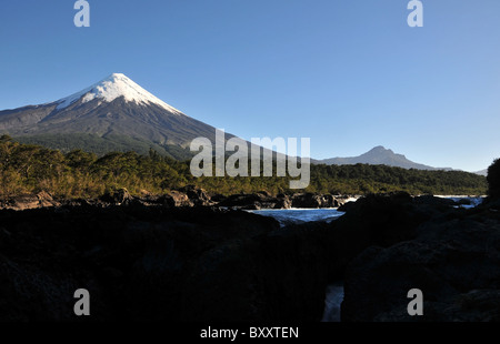 Cielo blu vista la mattina della cascata Petrohue con il cono di ghiaccio del Volcan Osorno sollevandosi al di sopra di foresta pluviale temperata, Cile Foto Stock