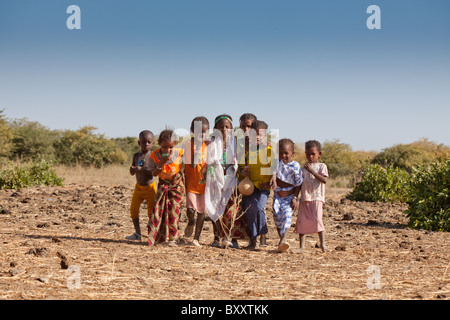 Nel villaggio di stagionali di Bantagiri nel nord del Burkina Faso, un gruppo di Fulani i bambini corrono verso la telecamera. Foto Stock