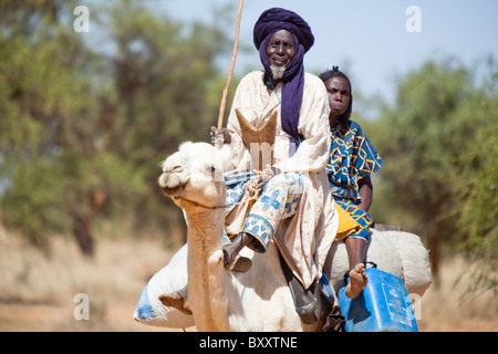 Un uomo Tuareg e sua moglie vieni al Villaggio Mercato di Bourro nel nord del Burkina Faso dal cammello. Foto Stock