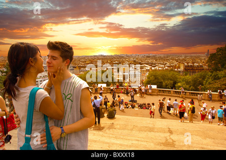 Coppia giovane circa al bacio sulla scalinata del Sacré-Coeur, Montmartre, Parigi al tramonto Foto Stock