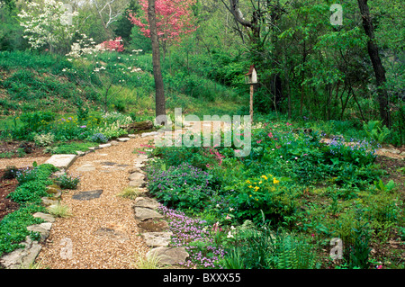 Primavera risveglia il giardino come colore sostituisce e si riempie con la nuova crescita - fiori di primavera benvenuti voi giù il percorso Foto Stock