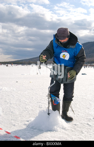 UST-BARGUZIN, Russia - 11 aprile: un fisher trapani un buco nel ghiaccio al quinto annuale Baikal Pesca, Aprile 11, 2009 in Ust-Bargu Foto Stock