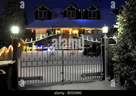 Vista sulla strada tempo invernale neve sul giardino anteriore luci elettriche e decorazioni natalizie bianche nevicate a dicembre Essex Inghilterra Regno Unito Foto Stock