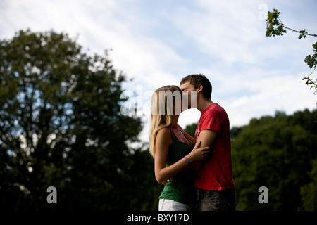 Una giovane coppia kissing all'aperto Foto Stock