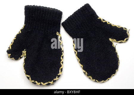 Una coppia di lana nera per bambini guanti su bianco Foto Stock