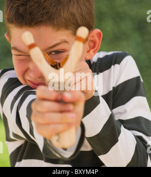 Boy utilizzando slingshot Foto Stock