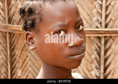 Una ragazza adolescente in Togo occhi la fotocamera. Il suo Paese ha partecipato a una generazione di reddito progetto per migliorare la povertà rurale. Foto Stock