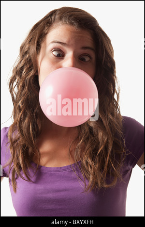 Giovane donna soffiando bubble gum Foto Stock