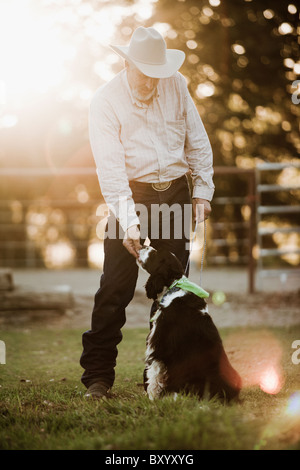 Alimentazione Cowboy cane sul ranch Foto Stock