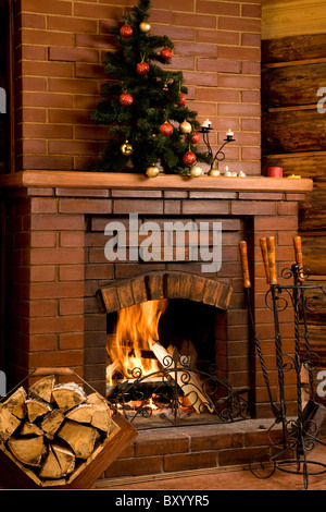 Immagine del camino con il fuoco interno e decorate albero sulla sua parte superiore
