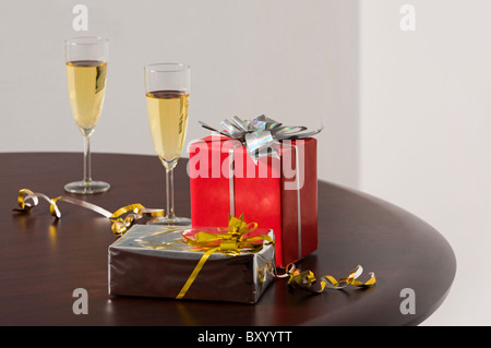 Immagine dei due presenta e flauti con lo champagne sul tavolo Foto Stock