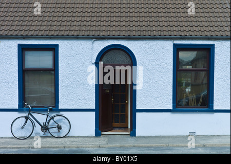 Scena di strada pebbledash bianchi bungalow a schiera e di biciclette a Kilkee, County Clare, Irlanda occidentale Foto Stock