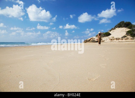 Donna che cammina sulla spiaggia, Tofo, Inhambane, Mozambico Foto Stock