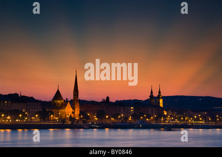 Budapest tramonto sulla Chiesa dei Cappuccini e la St Anne's chiesa attraverso il Fiume Danubio Budapest Ungheria Unione europea EUROPA Foto Stock