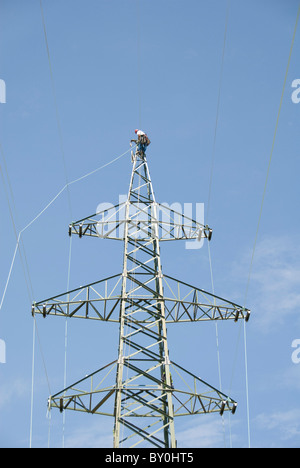 Lavoratore su un traliccio di elettricità di attaccare il cavo, Austria, Europa Foto Stock