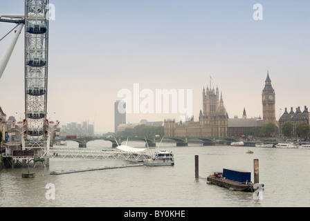 Vista lungo il fiume Tamigi, il London Eye e le case del Parlamento a distanza Foto Stock